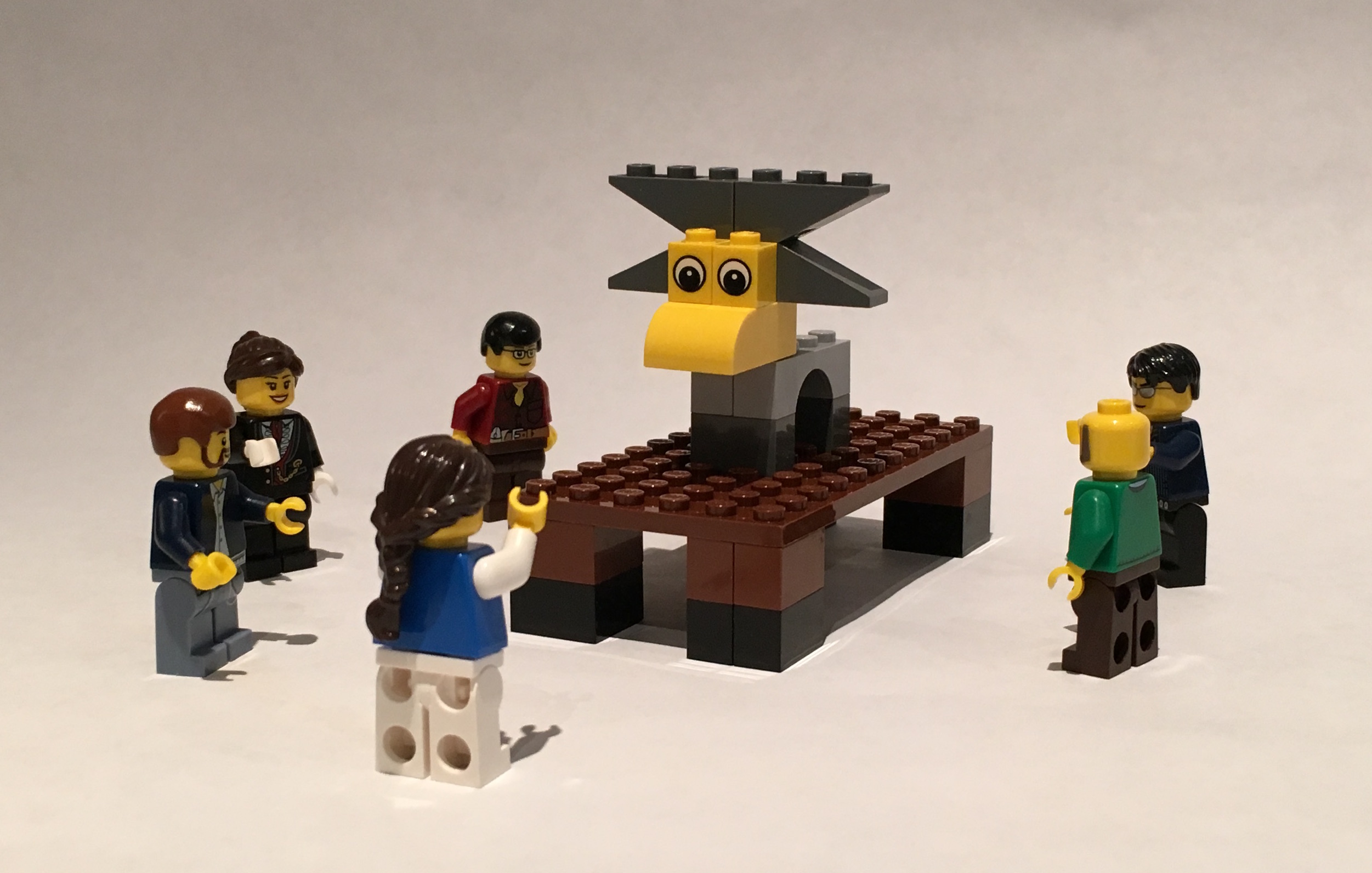 A LEGO model of a moose with people standing around it.